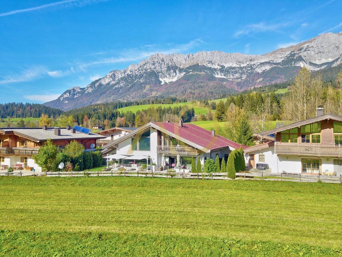 Die moderne Villa fügt sich harmonisch in die alpine Landschaft mit Bergblick ein.