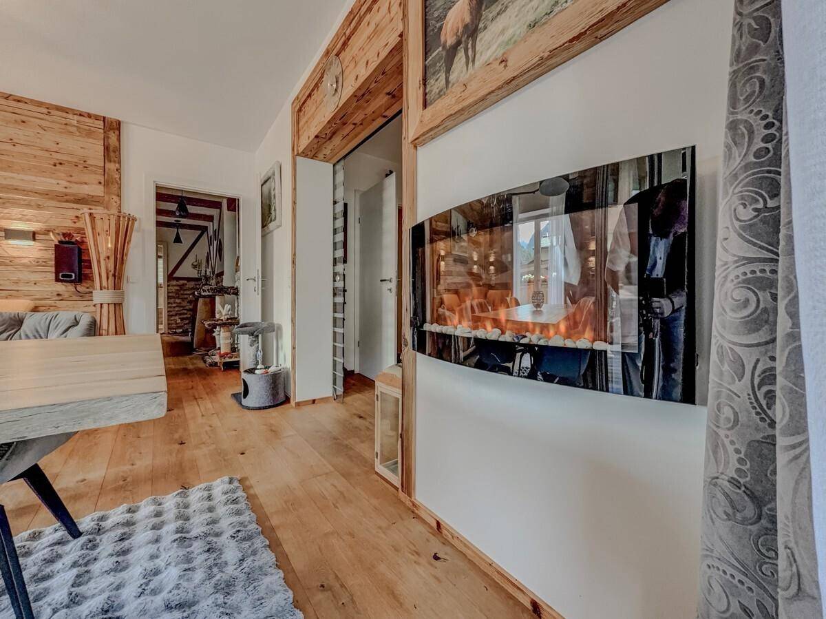 Flur mit Holzboden und einer modernen Wanddekoration, die einen Kamin simuliert.