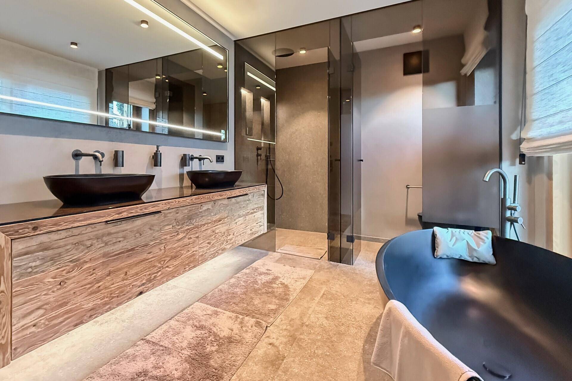 Elegantes Badezimmer mit freistehender Badewanne, Doppelwaschbecken und Glasdusche.