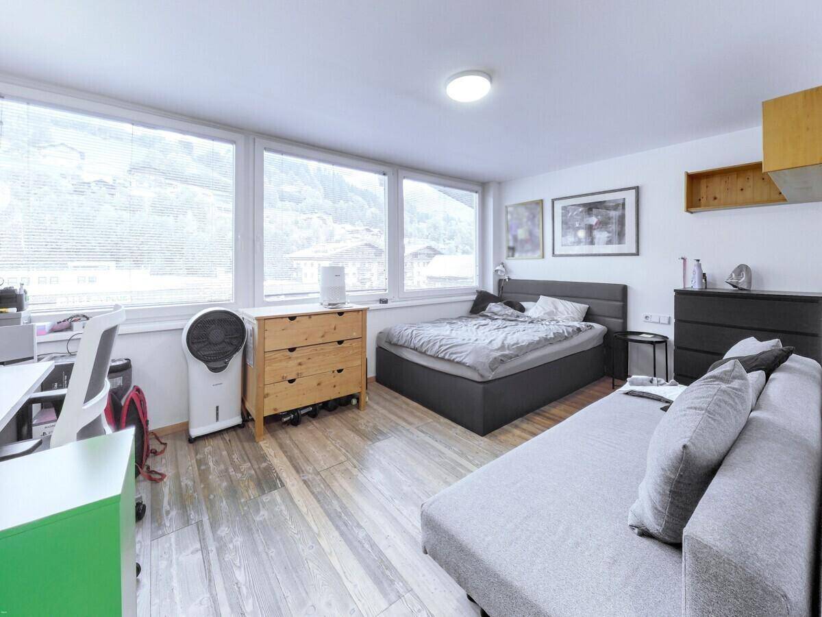 Geräumiges Schlafzimmer mit Bett, Sofa und großen Fenstern mit weitem Blick auf die Landschaft.