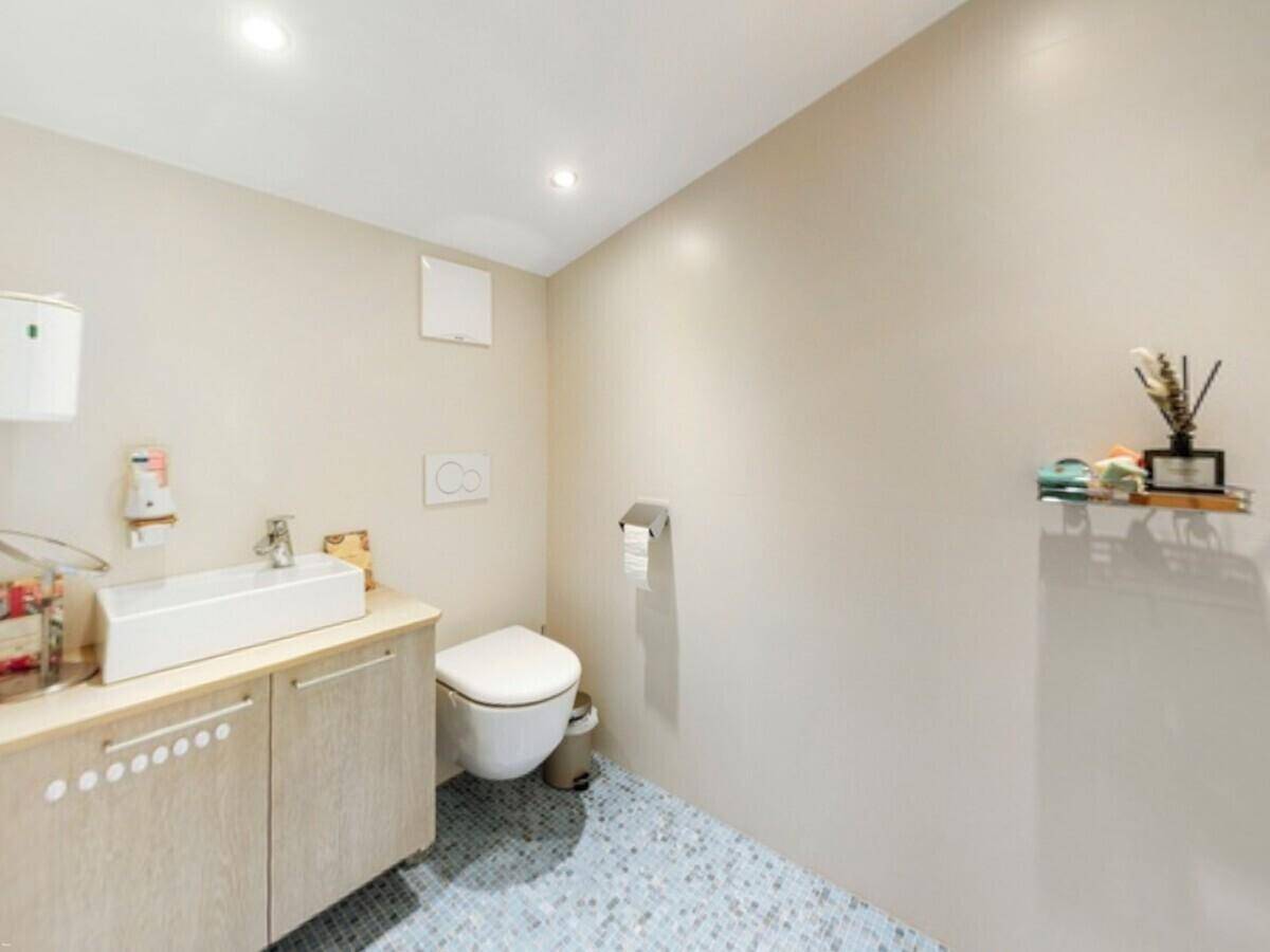 Modernes Gäste-WC mit Wand-WC, Einzelwaschbecken und kleinem Mosaikfliesenboden.