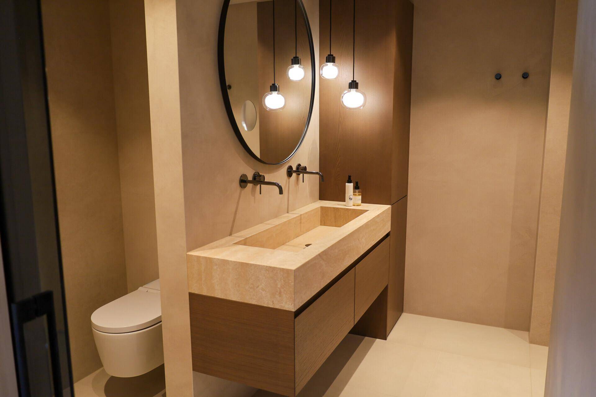 Elegantes Gäste-WC mit schwebendem Waschtisch aus Naturstein und modernem Design.