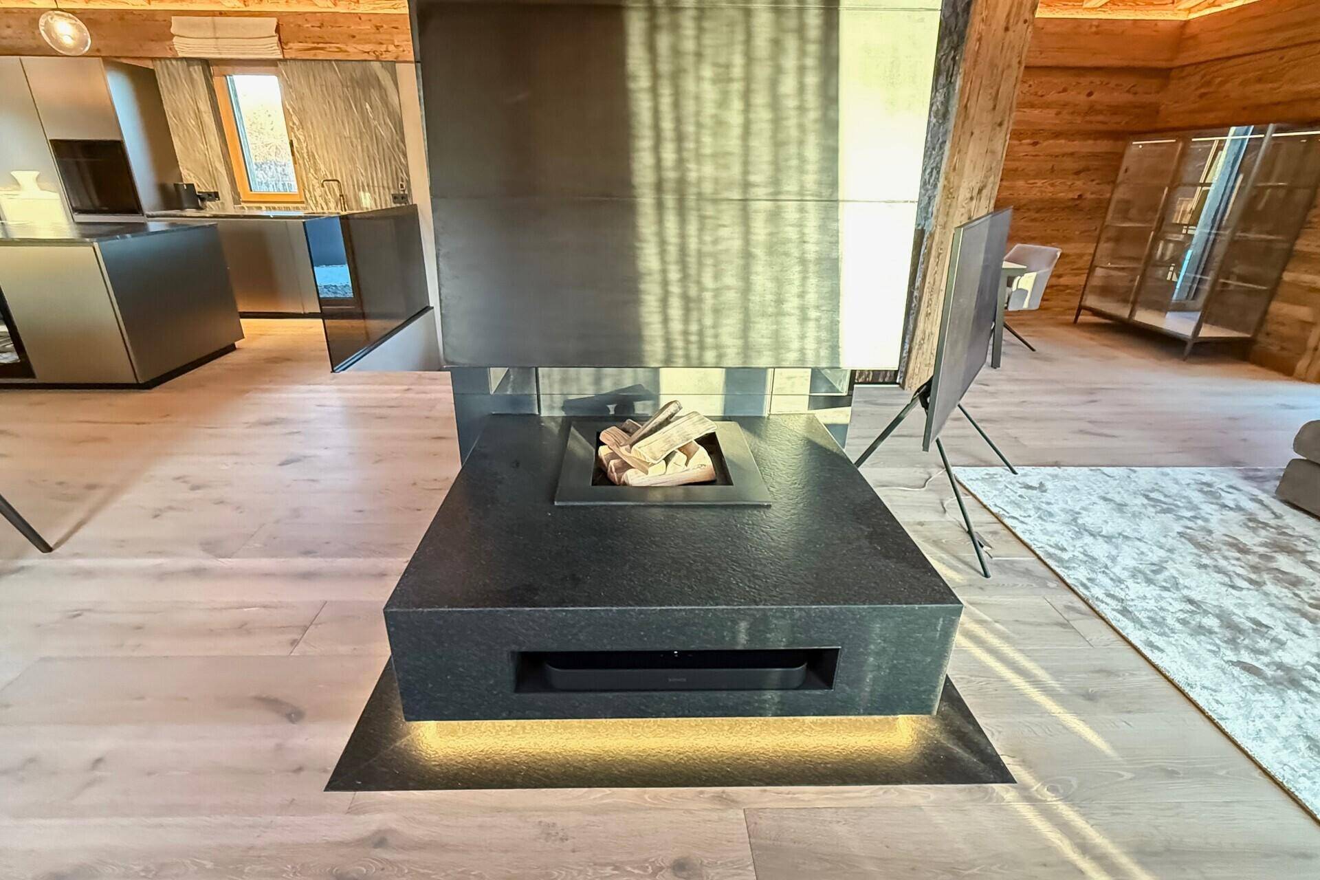 Moderner Kamin im Wohnbereich, der Wärme und Atmosphäre spendet, mit Holzscheiten dekoriert.