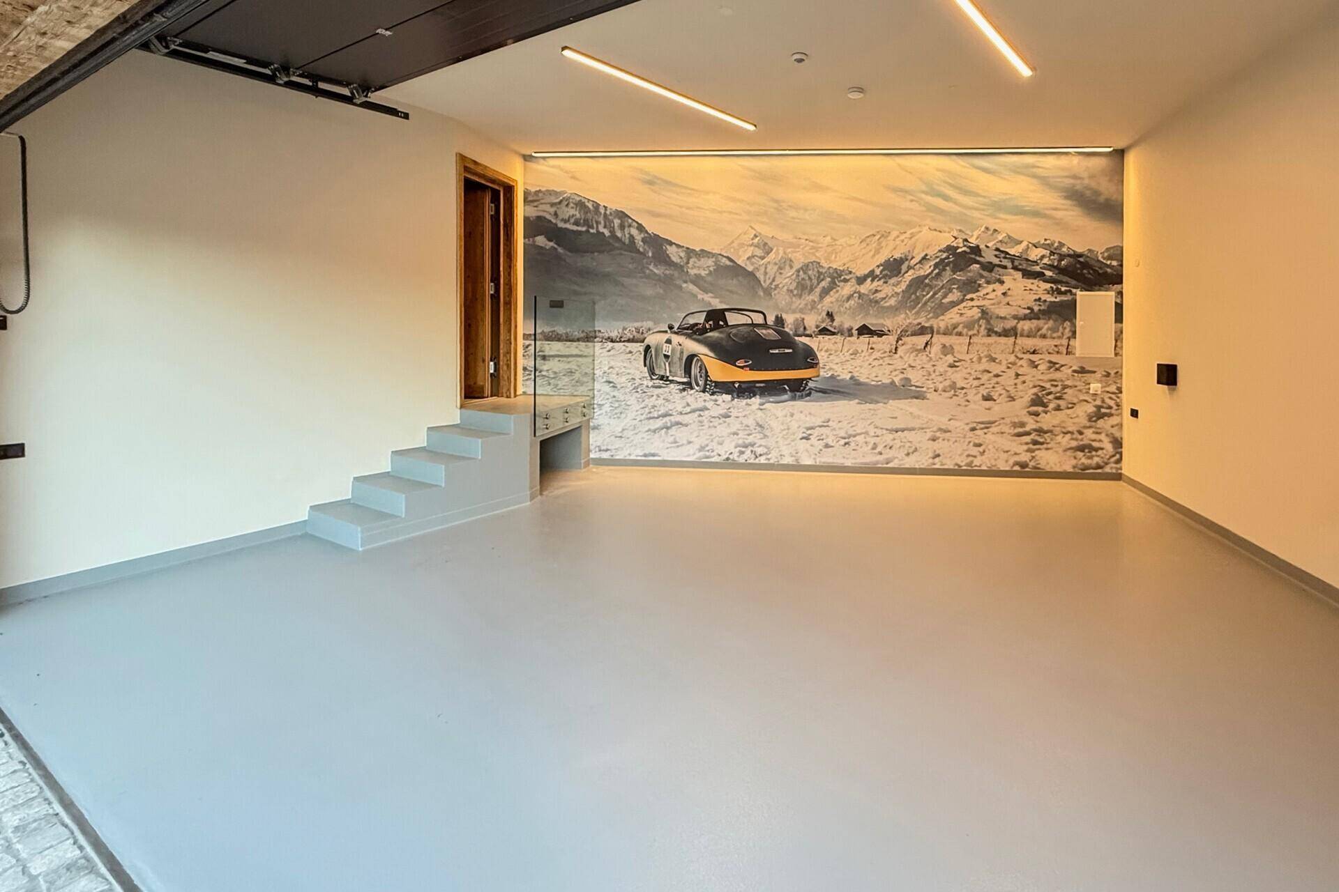 Geräumige Garage mit glattem Boden und Wandbild, ideal für Fahrzeuge und Lagerung.
