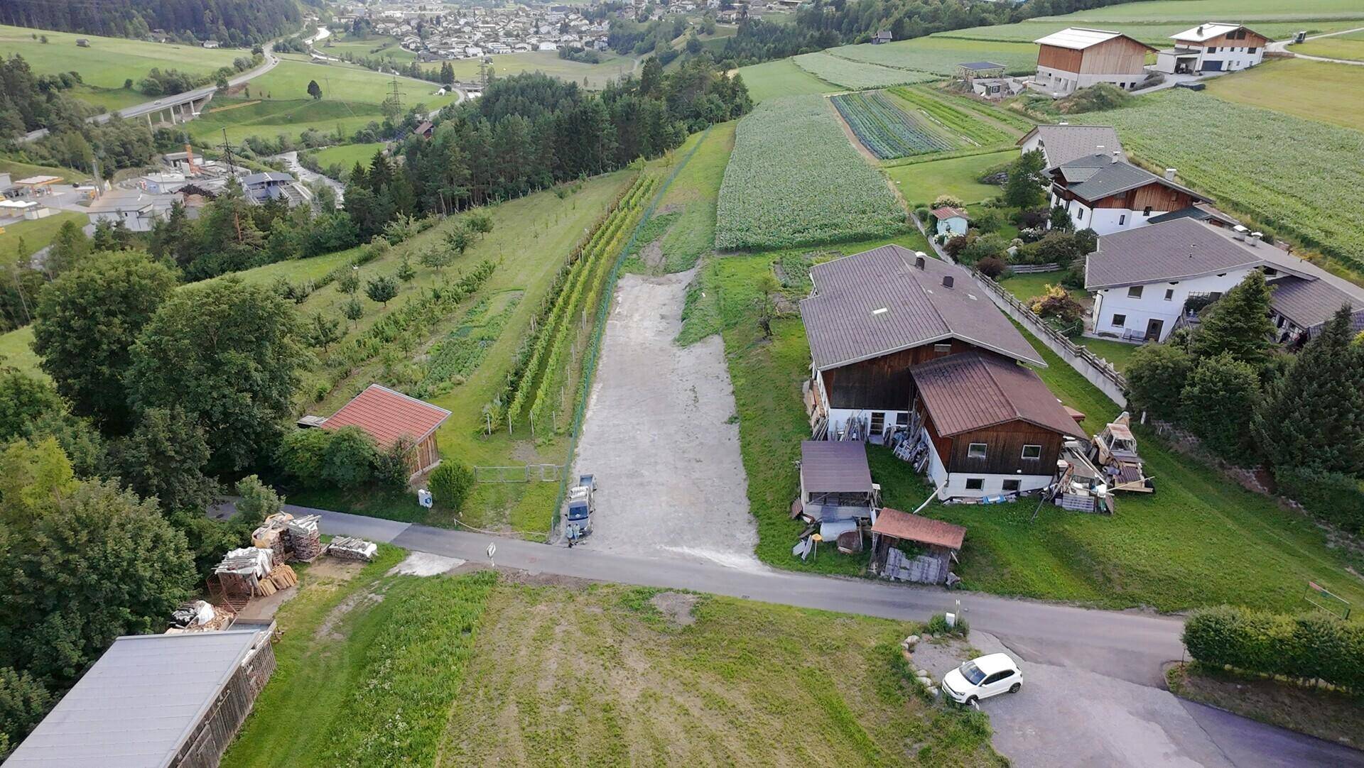 Luftaufnahme einer weitläufigen Landschaft mit Feldern, Weinbergen und verstreuten Häusern.