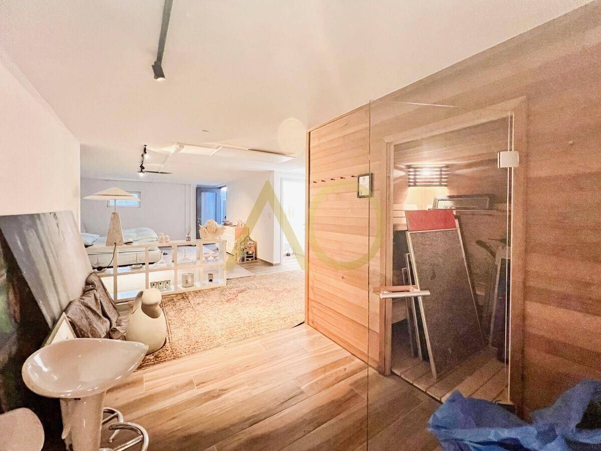 Geräumiges Schlafzimmer mit modernem Bett, offenem Regal und angrenzendem Badezimmer.
