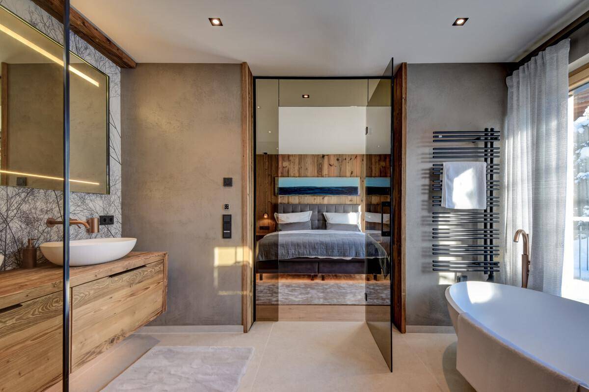 Elegantes Badezimmer mit freistehender Badewanne, begehbarer Dusche und direktem Zugang zum Schlafzimmer.
