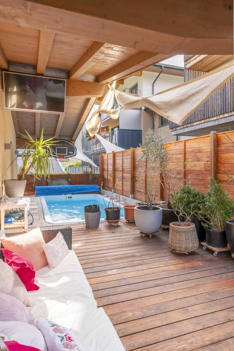 Entspannender Außenbereich mit Holzterrasse, kleinem Pool und bequemen Lounge-Möbeln.
