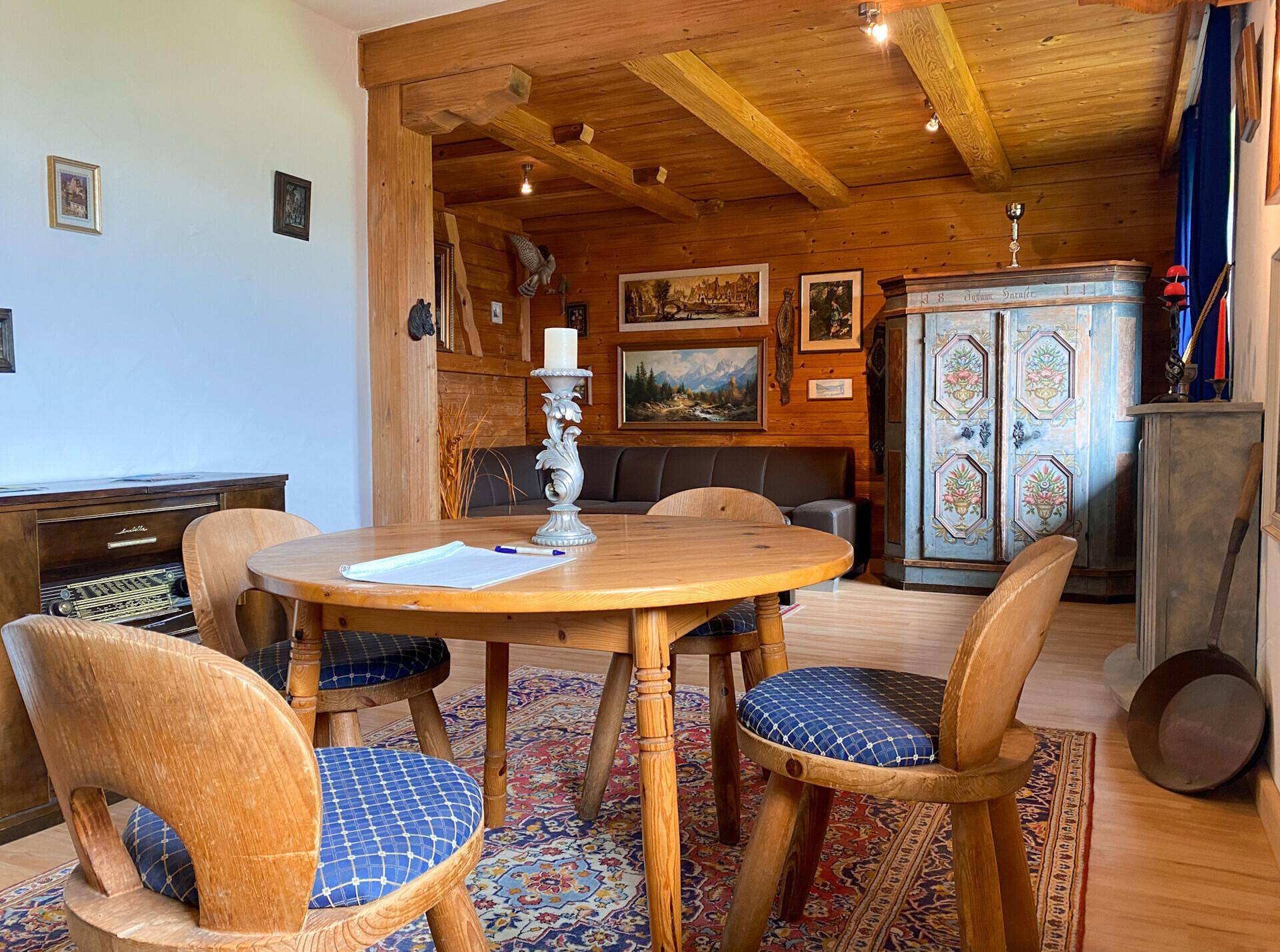 Gemütlicher Essbereich mit Holztisch und Stühlen, umgeben von rustikalen Holzvertäfelungen und traditioneller Dekoration.