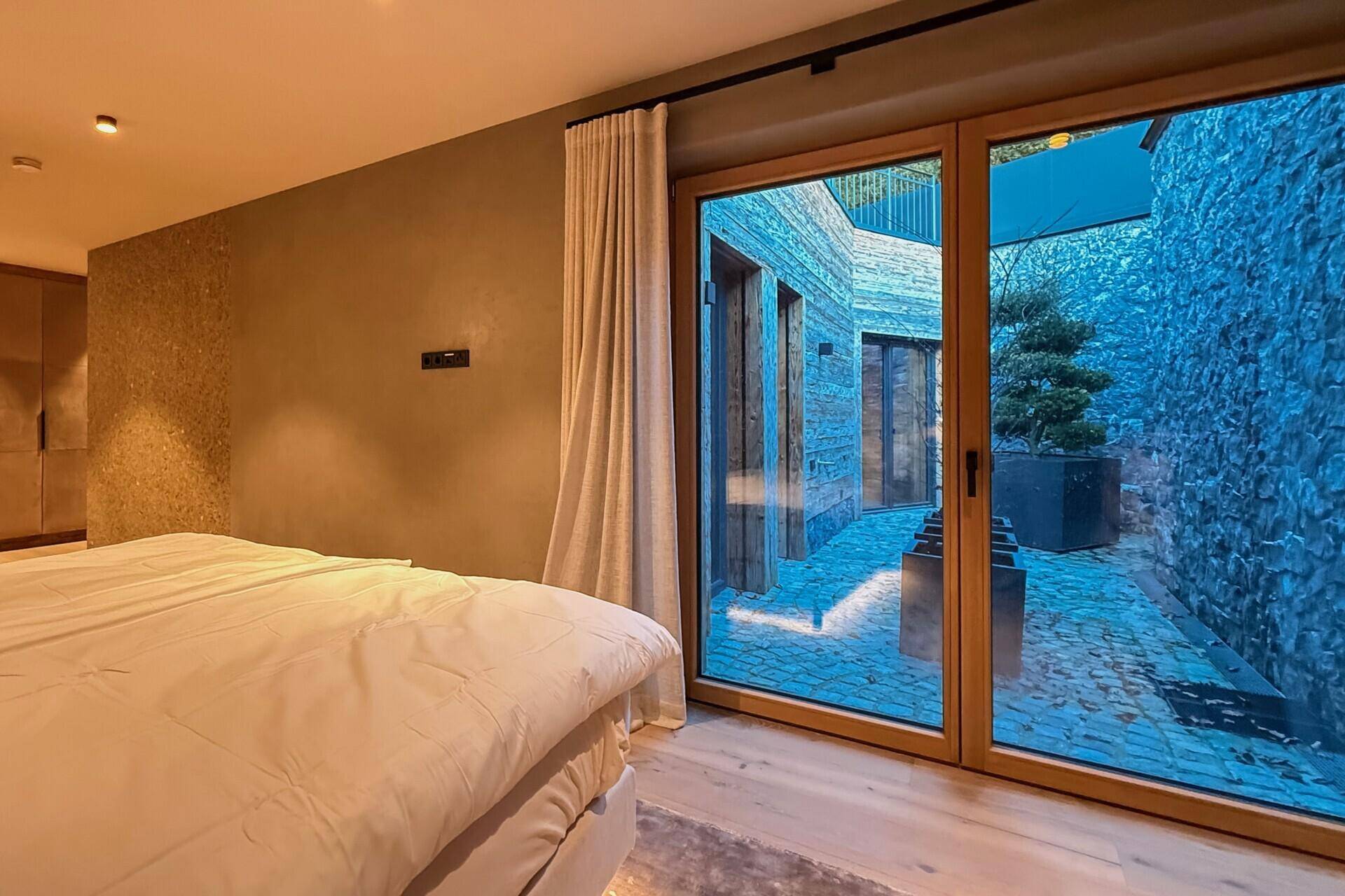 Schlafzimmer mit Zugang zu einem kleinen Innenhof, der Privatsphäre und natürliches Licht bietet.