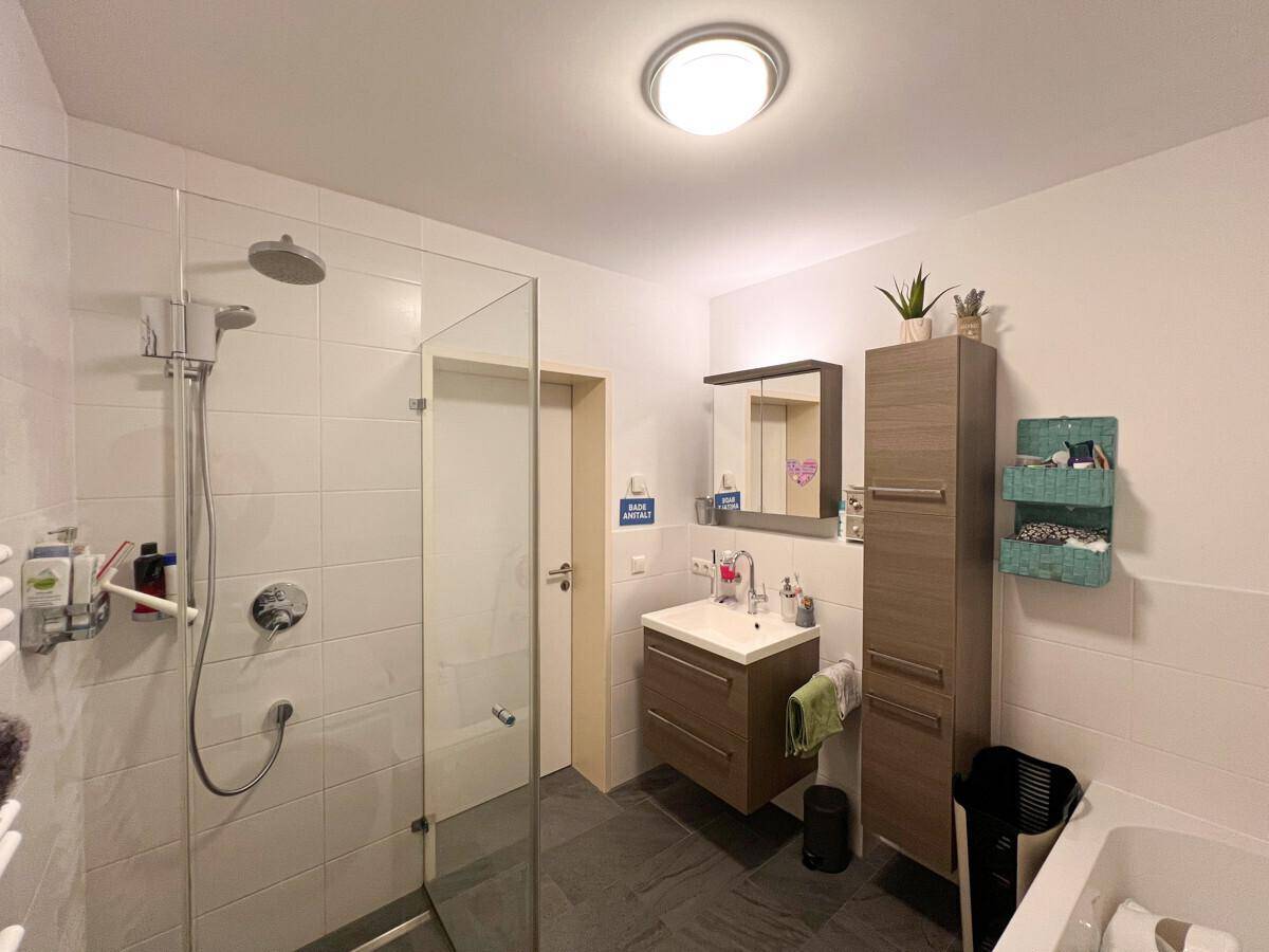 Gäste-WC mit wandhängender Toilette, modernem Waschbecken und stilvollen Fliesen.