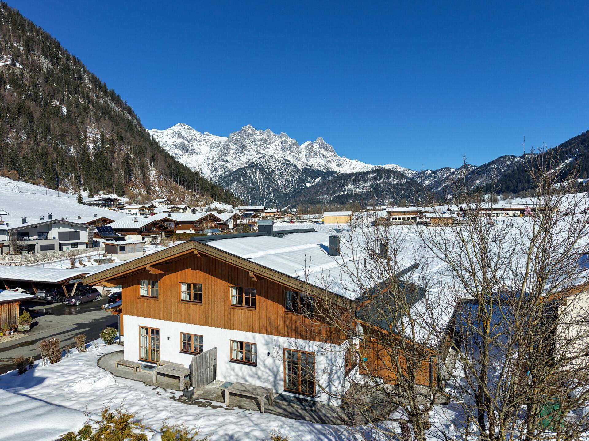Chalet in verschneiter Landschaft mit beeindruckendem Blick auf die majestätischen Berge.