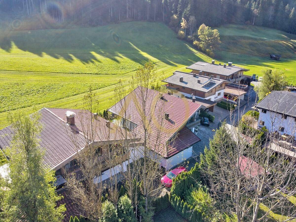 Luftaufnahme der Villa mit rotem Dach und umliegender grüner Landschaft.