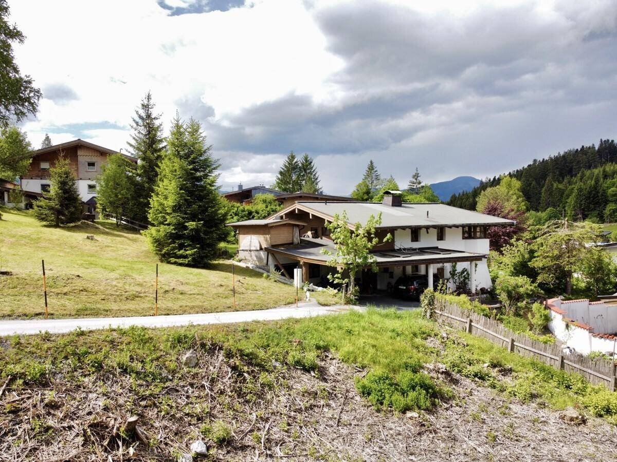 Bestehendes Wohnhaus mit Carport und grüner Umgebung in ländlicher Lage.