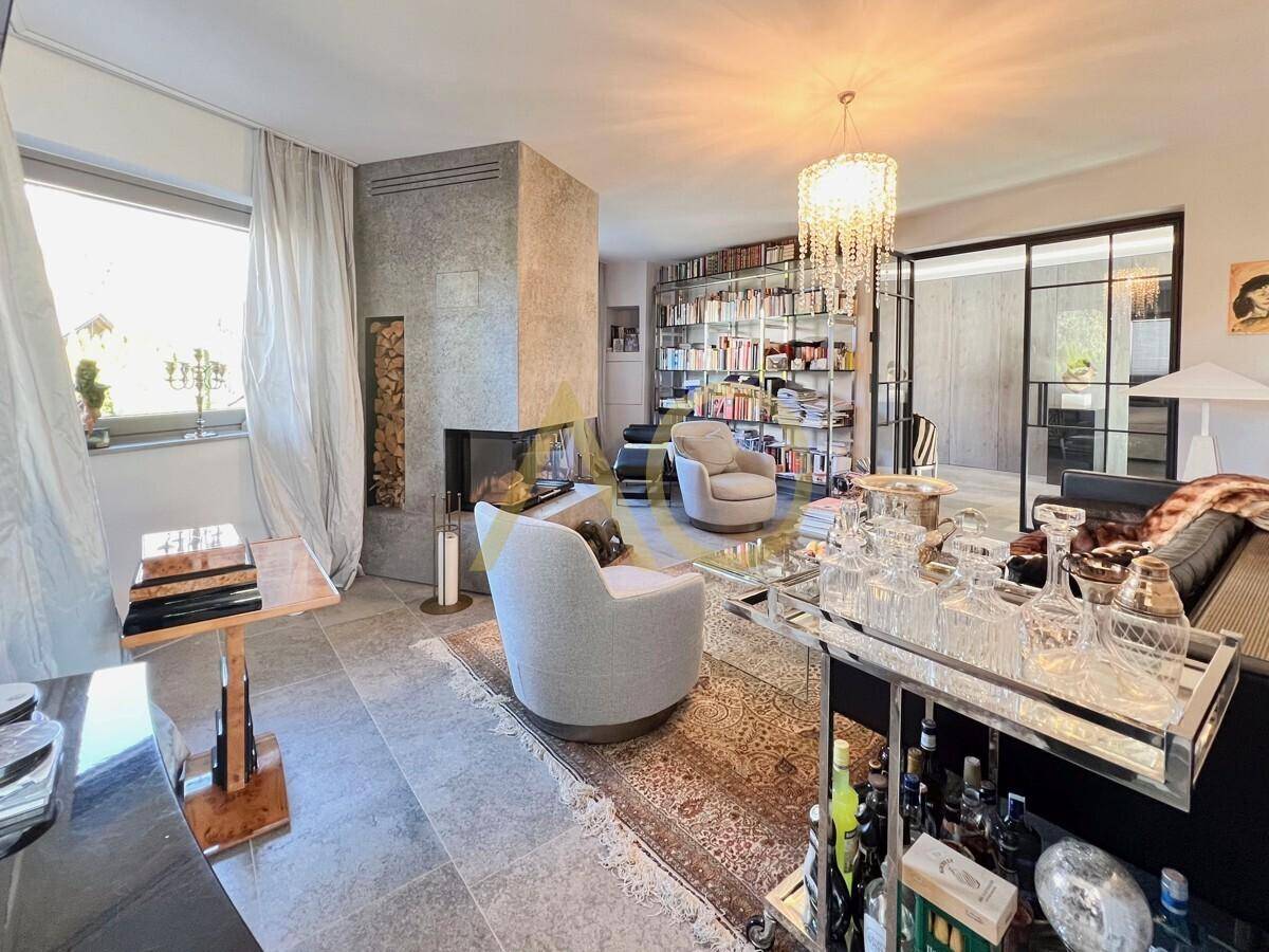 Elegantes Wohnzimmer mit Kamin, Bücherregal und stilvoller Bar.