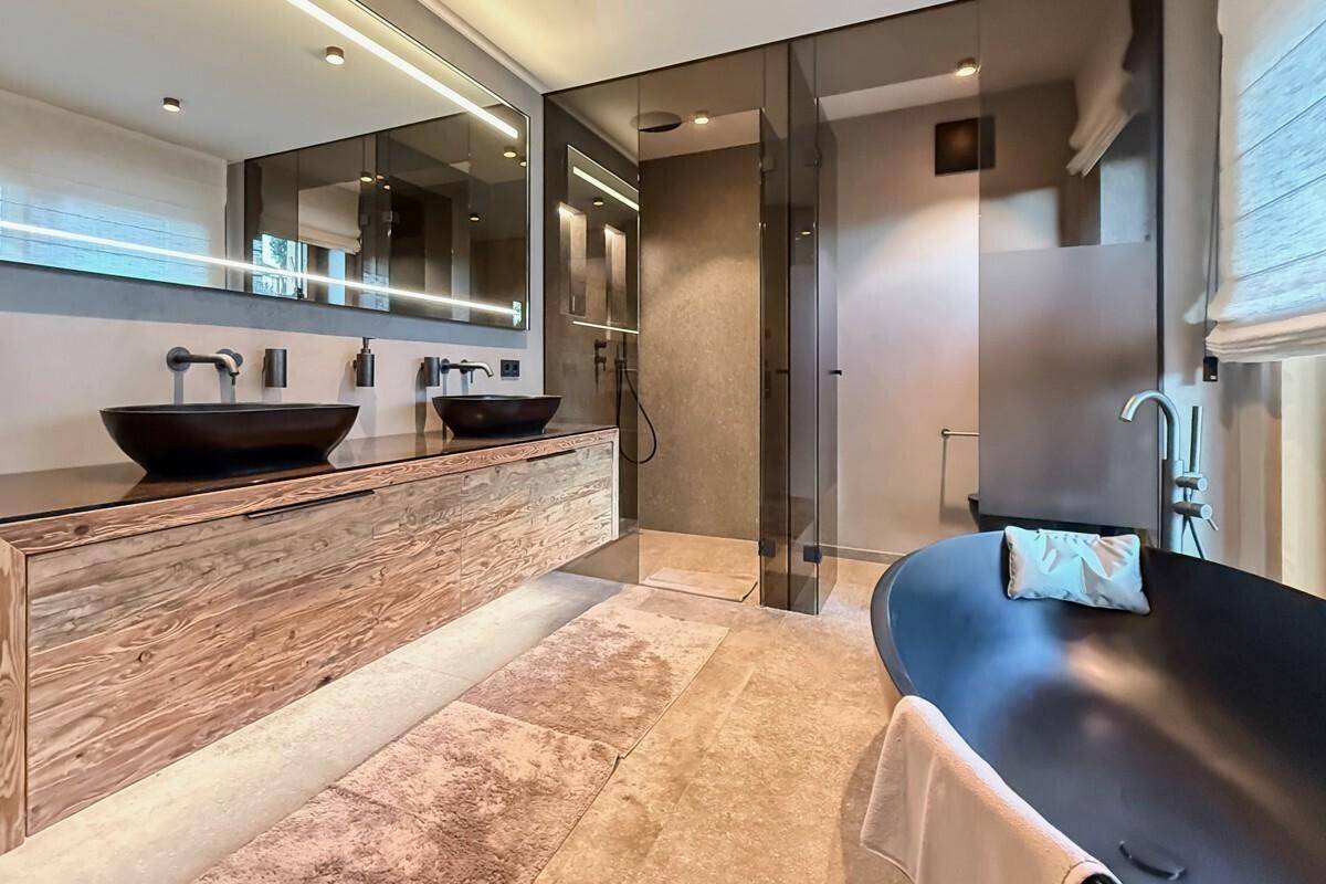 Luxuriöses Badezimmer mit freistehender Badewanne, Doppelwaschbecken und begehbarer Dusche.