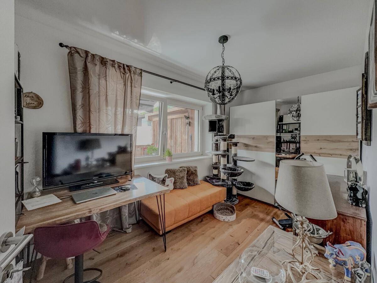 Helles Arbeitszimmer mit Schreibtisch, Holzboden und Blick ins Grüne.