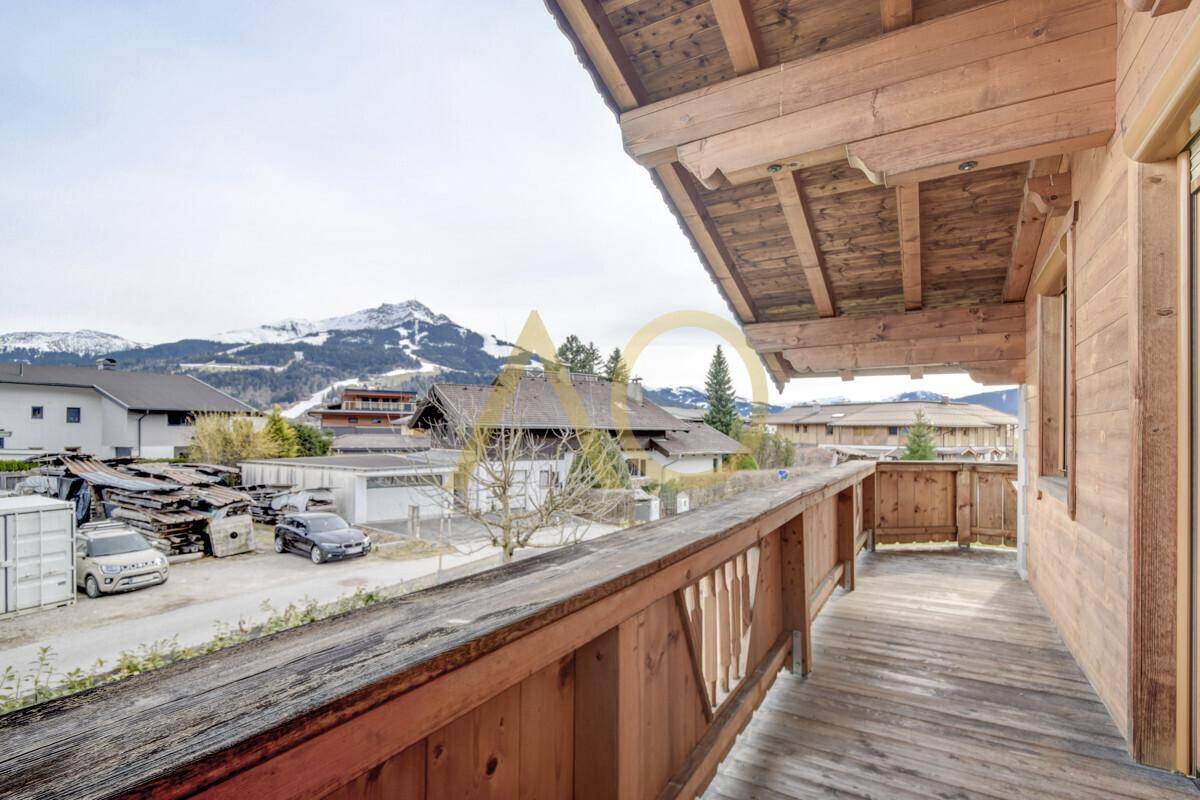 Geräumiger Holzbalkon mit Blick auf die umliegende Berglandschaft und das Tal.