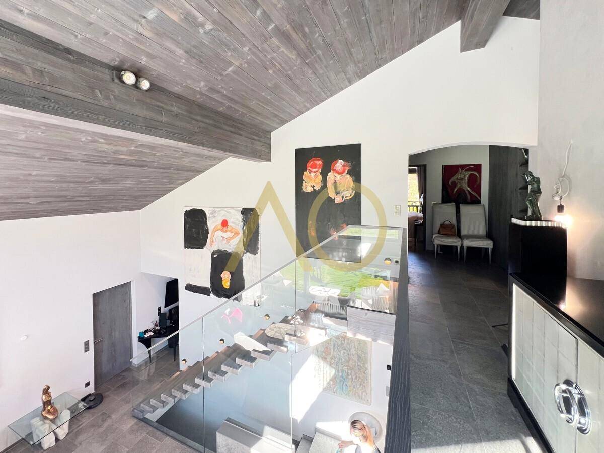 Offener Wohnbereich mit Galerie, moderner Treppe und Kunstwerken an den Wänden.