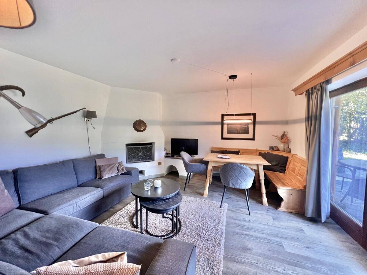 Moderner Wohn- und Essbereich mit Kamin, Sofa und Zugang zur Terrasse.
