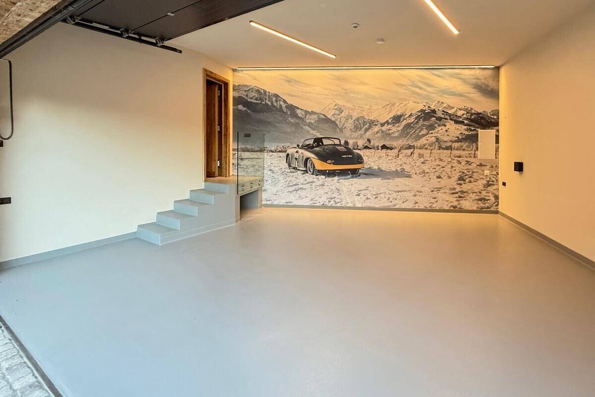 Geräumige Garage mit Wandbild und ausreichend Platz für Fahrzeuge.