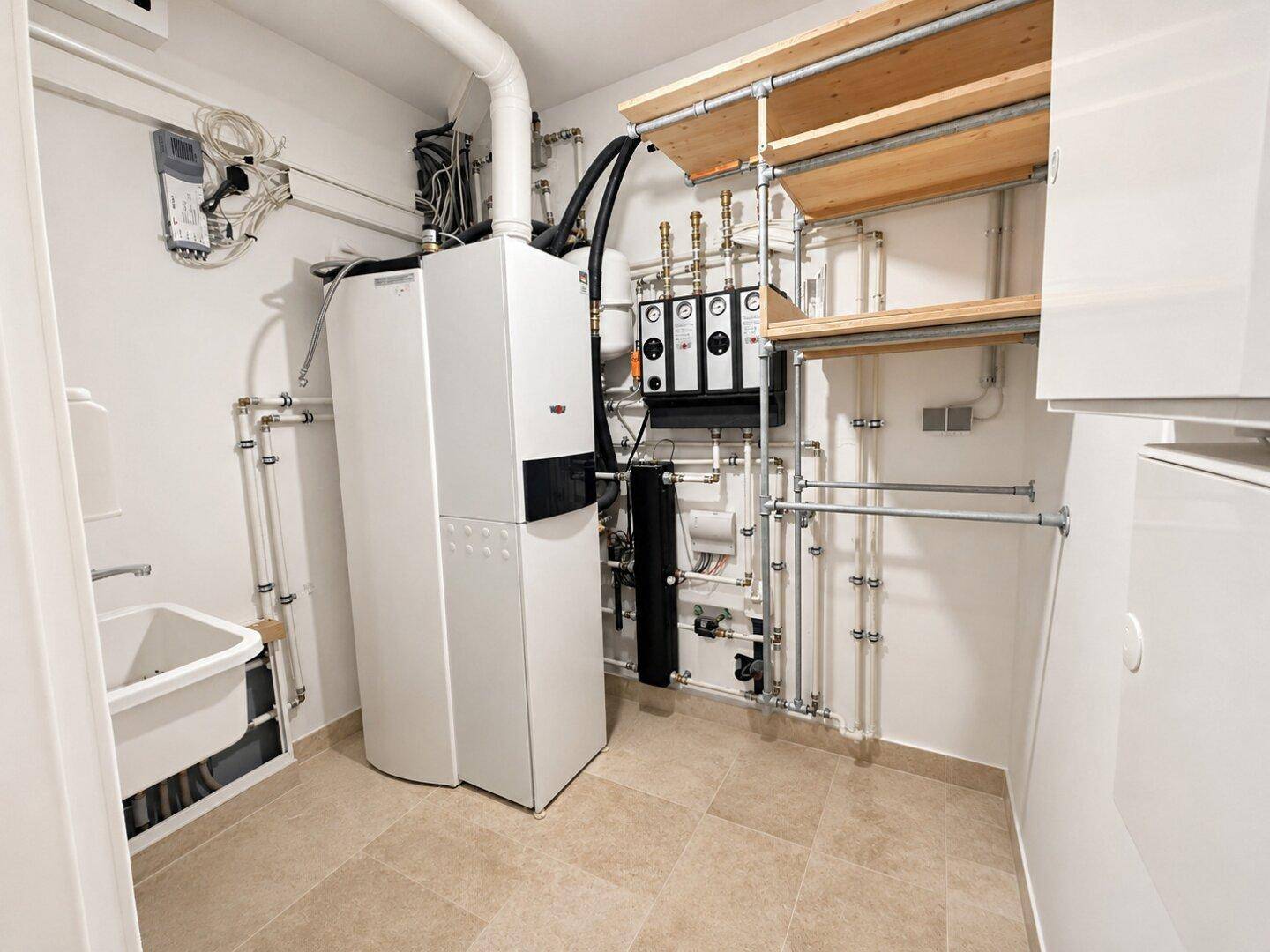 Funktionaler Hauswirtschaftsraum mit Heizungsanlage, Rohren und praktischen Ablageregalen.
