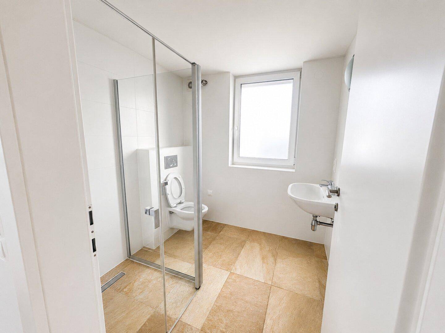Modernes Badezimmer mit ebenerdiger Dusche, wandhängendem WC, Einzelwaschbecken und Fenster.