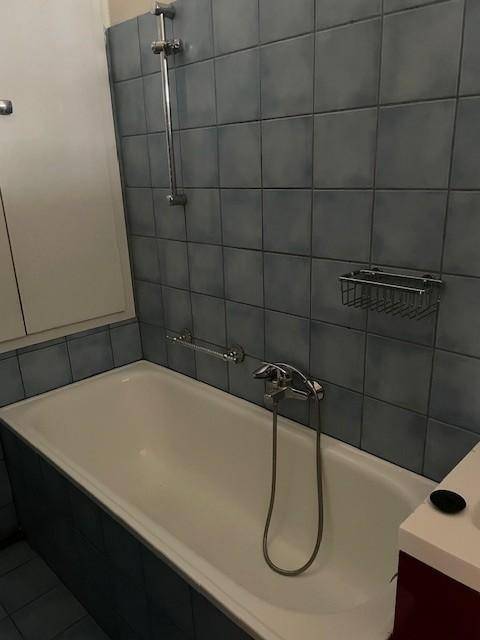 Badezimmer mit blauen Fliesen und einer Badewanne, die zum Entspannen einlädt.