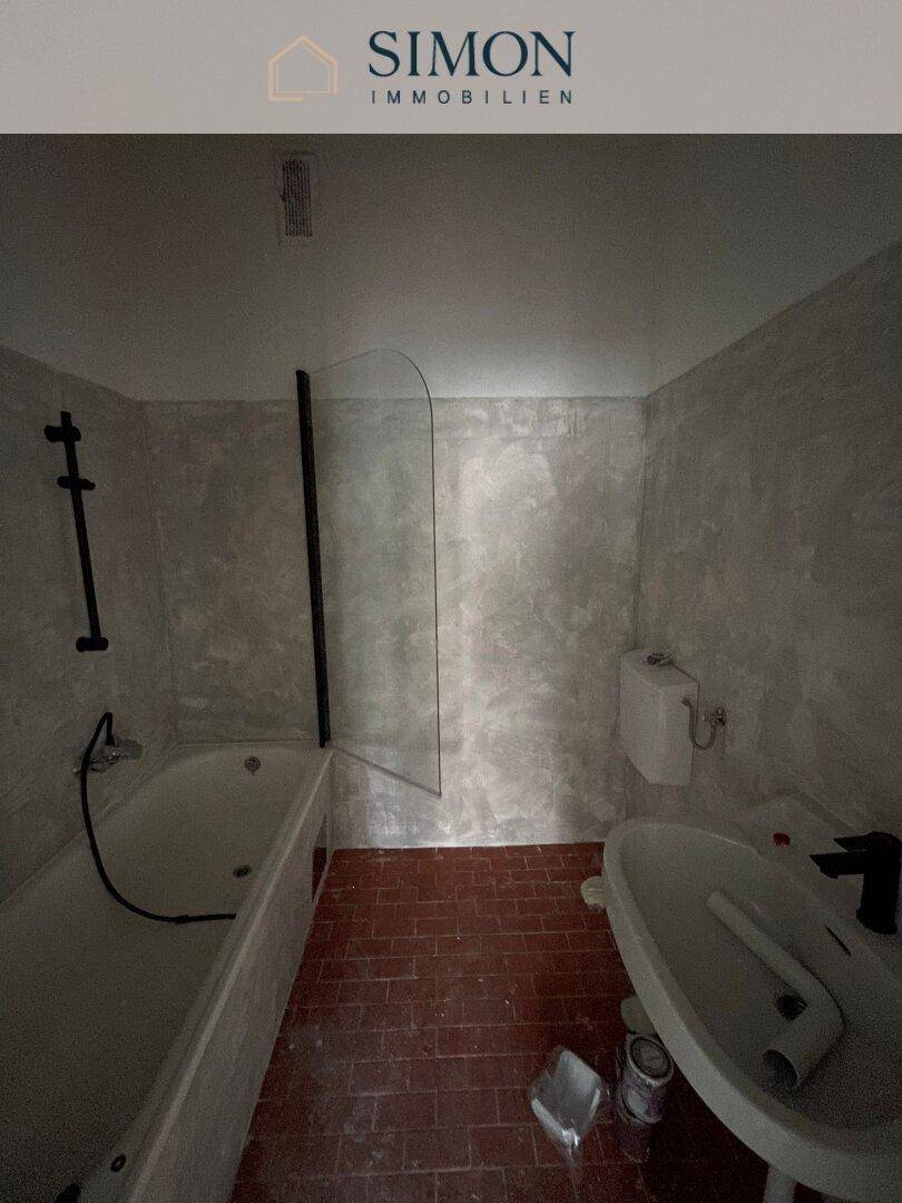 Badezimmer mit Duschwanne und WC