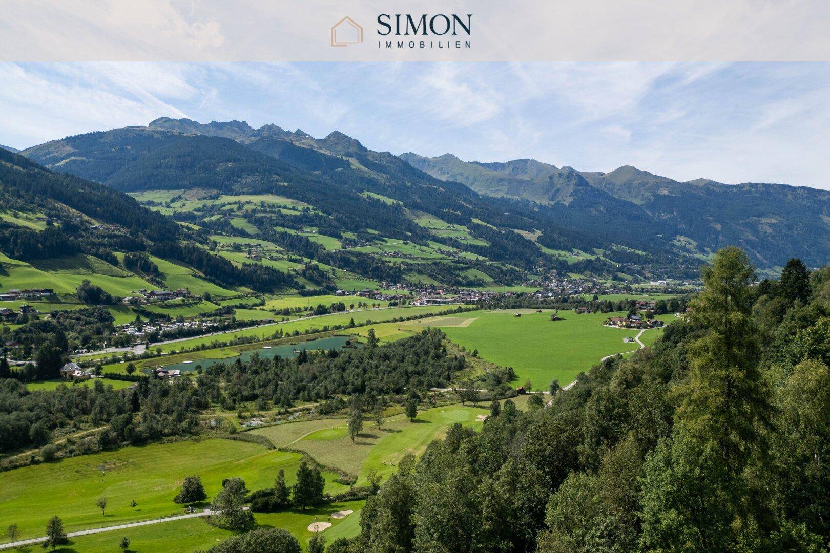 Weitläufige Panoramaaussicht auf die grüne Berglandschaft mit Tälern und Golfplatz.