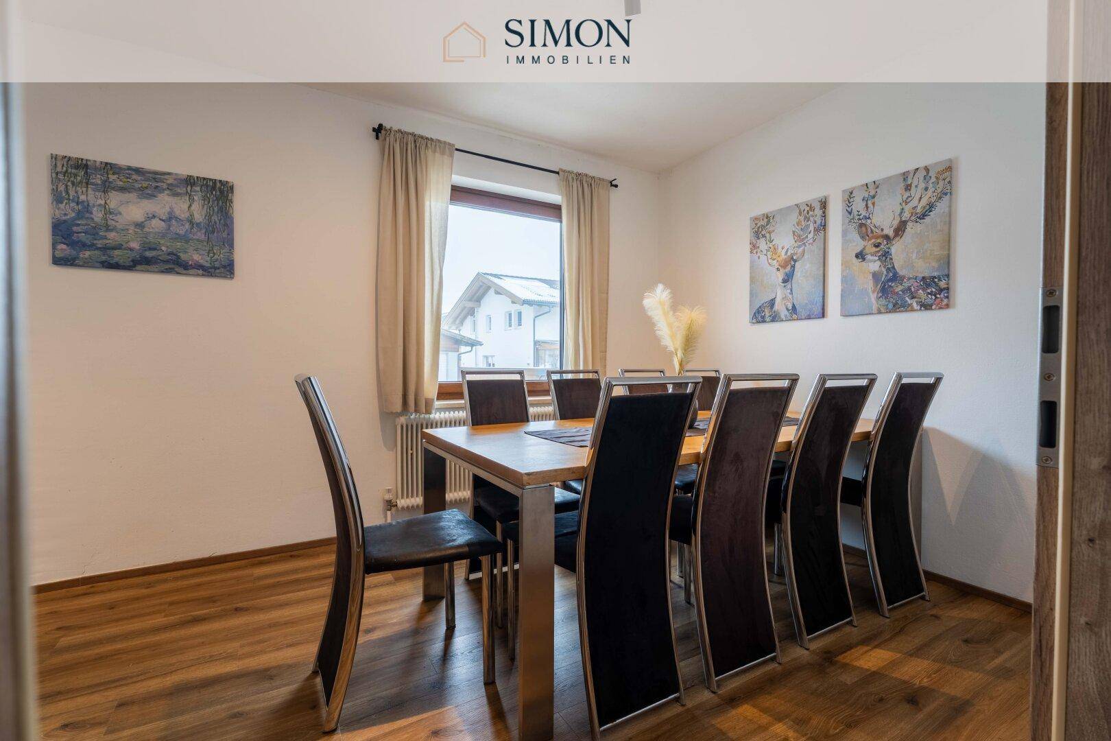 Esszimmer mit großem Holztisch, acht Stühlen und Laminatboden, ideal für Familienessen.