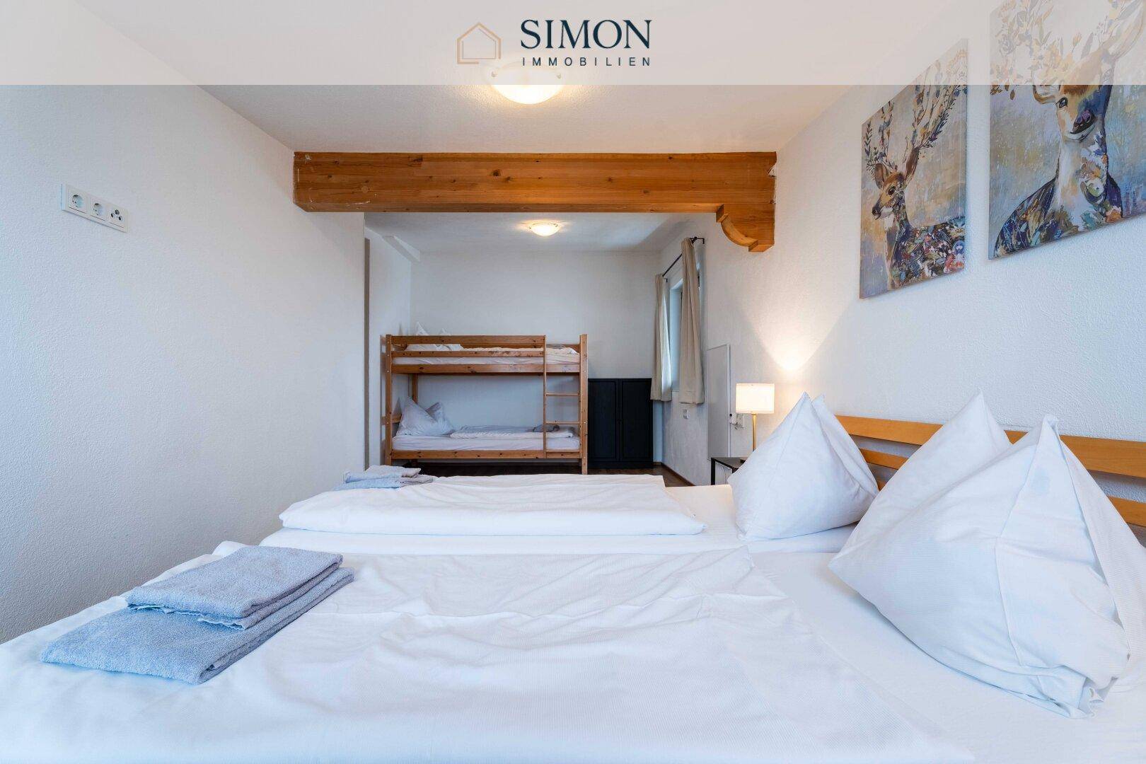 Geräumiges Schlafzimmer mit Doppelbett und Etagenbett, ideal für Familien oder Gäste.