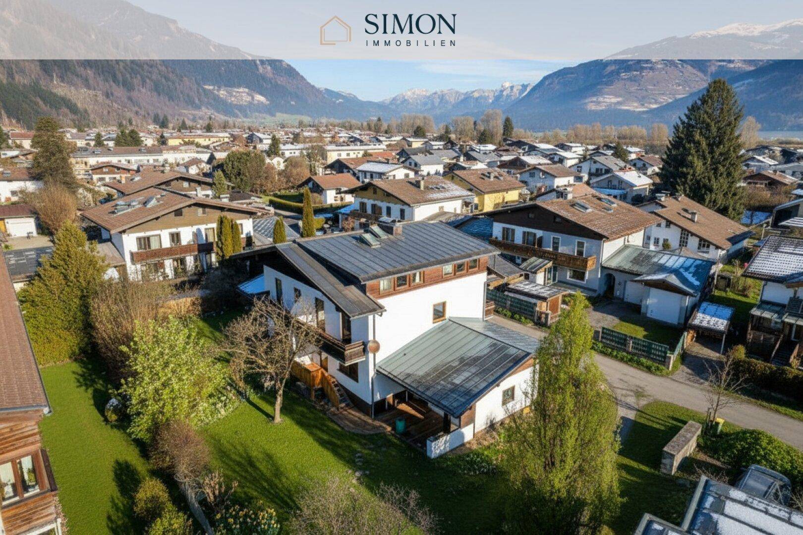 Panoramablick auf das Wohnhaus in einer Siedlung mit grüner Umgebung und Bergen im Hintergrund.