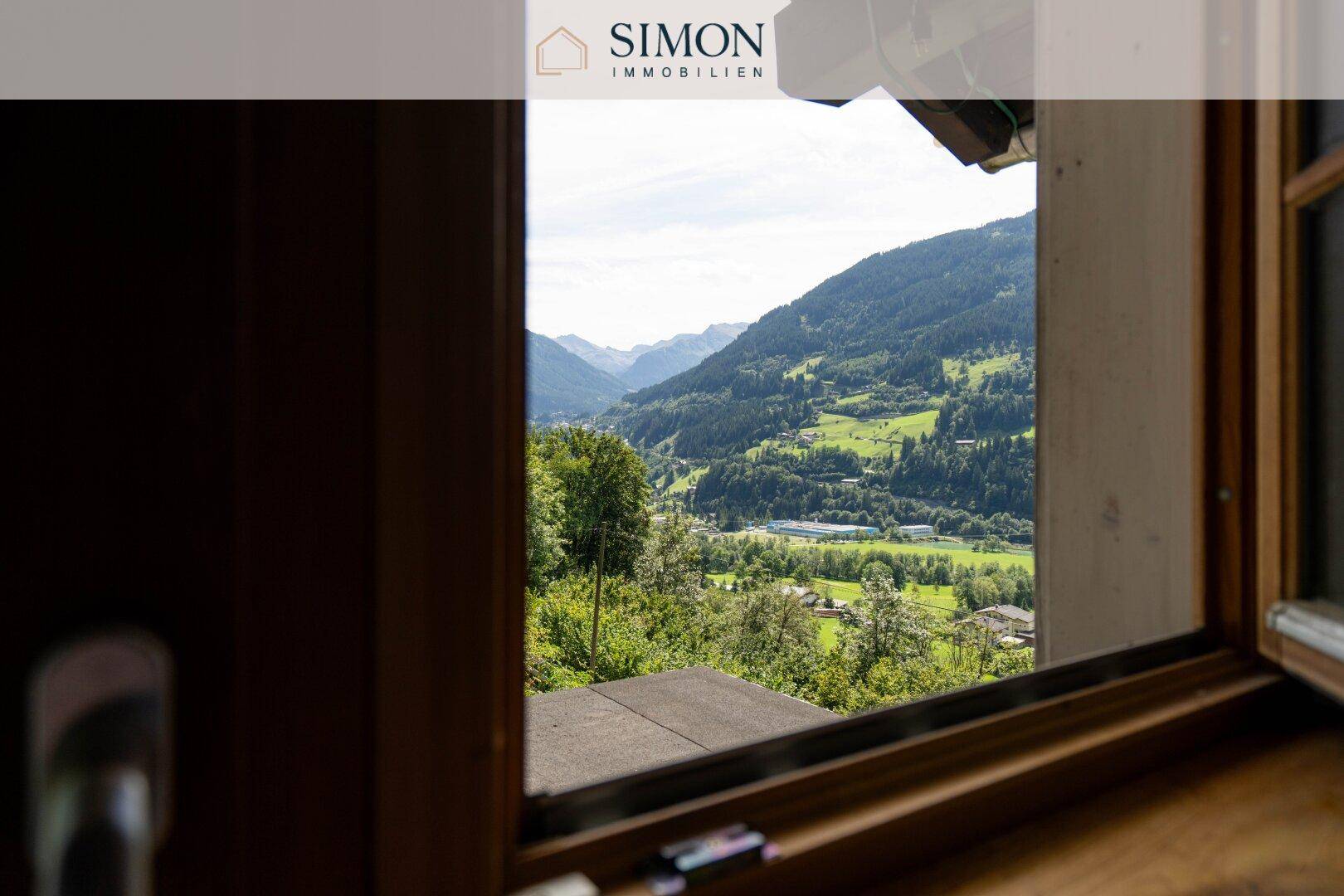 Malerischer Ausblick aus dem Fenster auf die grüne Berglandschaft und das Tal.