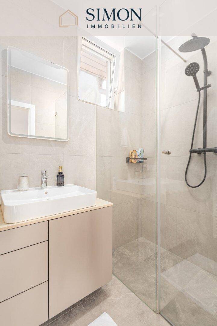 Modernes Badezimmer mit begehbarer Dusche, Waschtisch und Fenster für Tageslicht.
