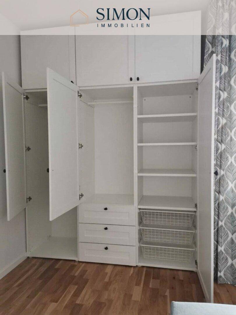 Praktischer weißer Einbauschrank mit viel Stauraum und verschiedenen Fächern im Schlafzimmer.