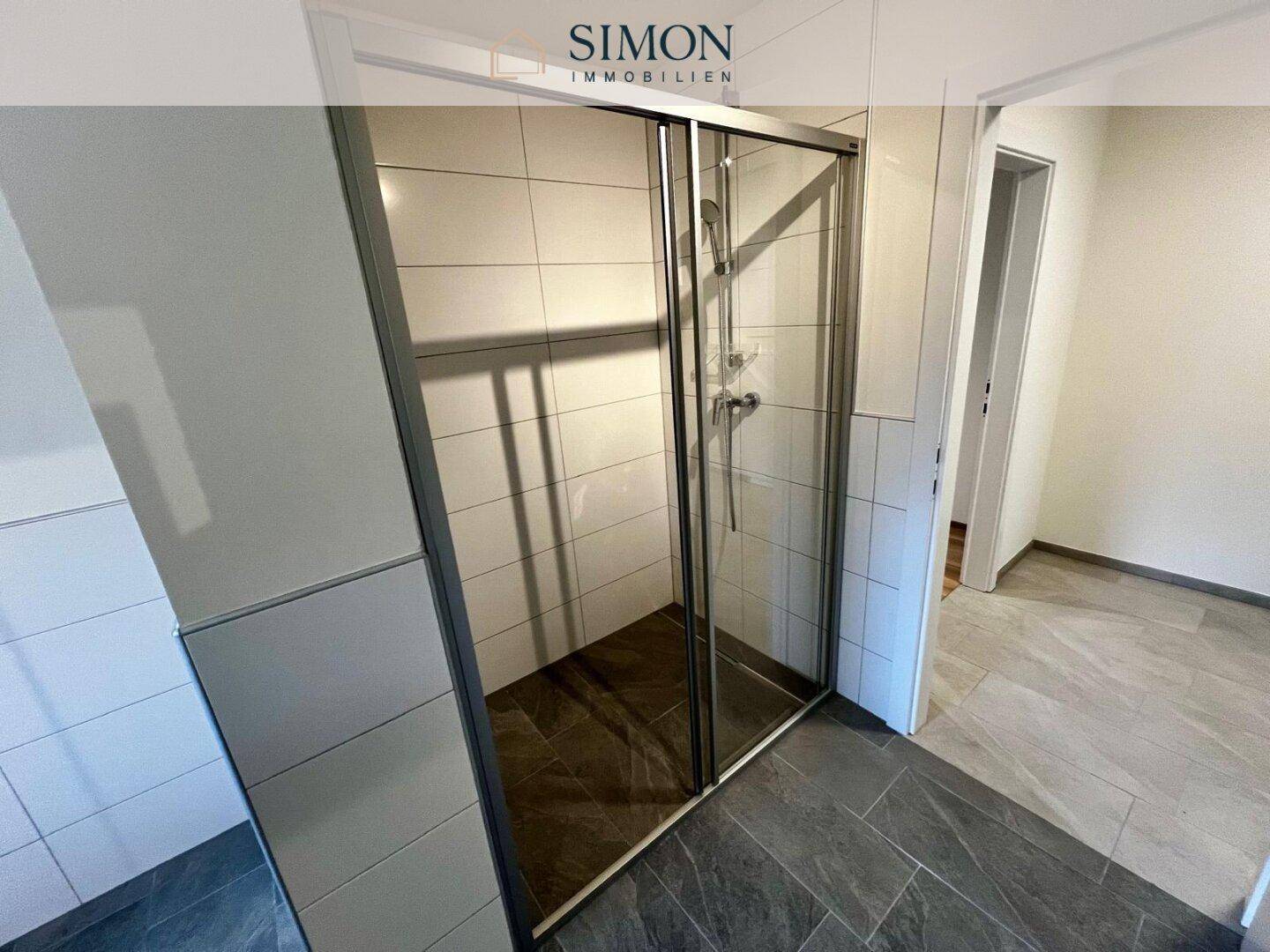 Geräumige Duschkabine mit Glastüren und modernen Fliesen im Badezimmer.
