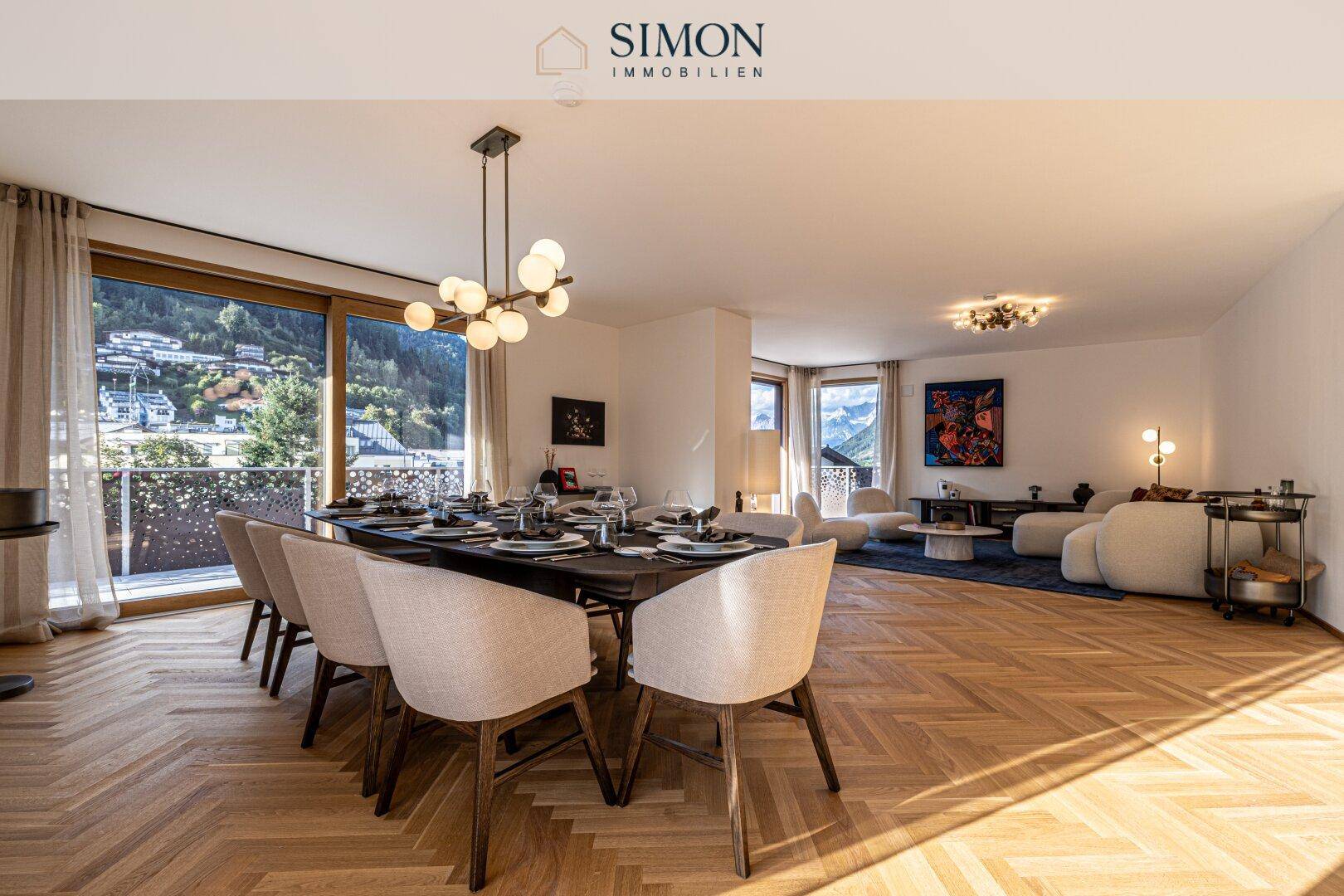 Heller, offener Wohn-Essbereich mit elegantem Esstisch, Parkettboden und Zugang zum Balkon.