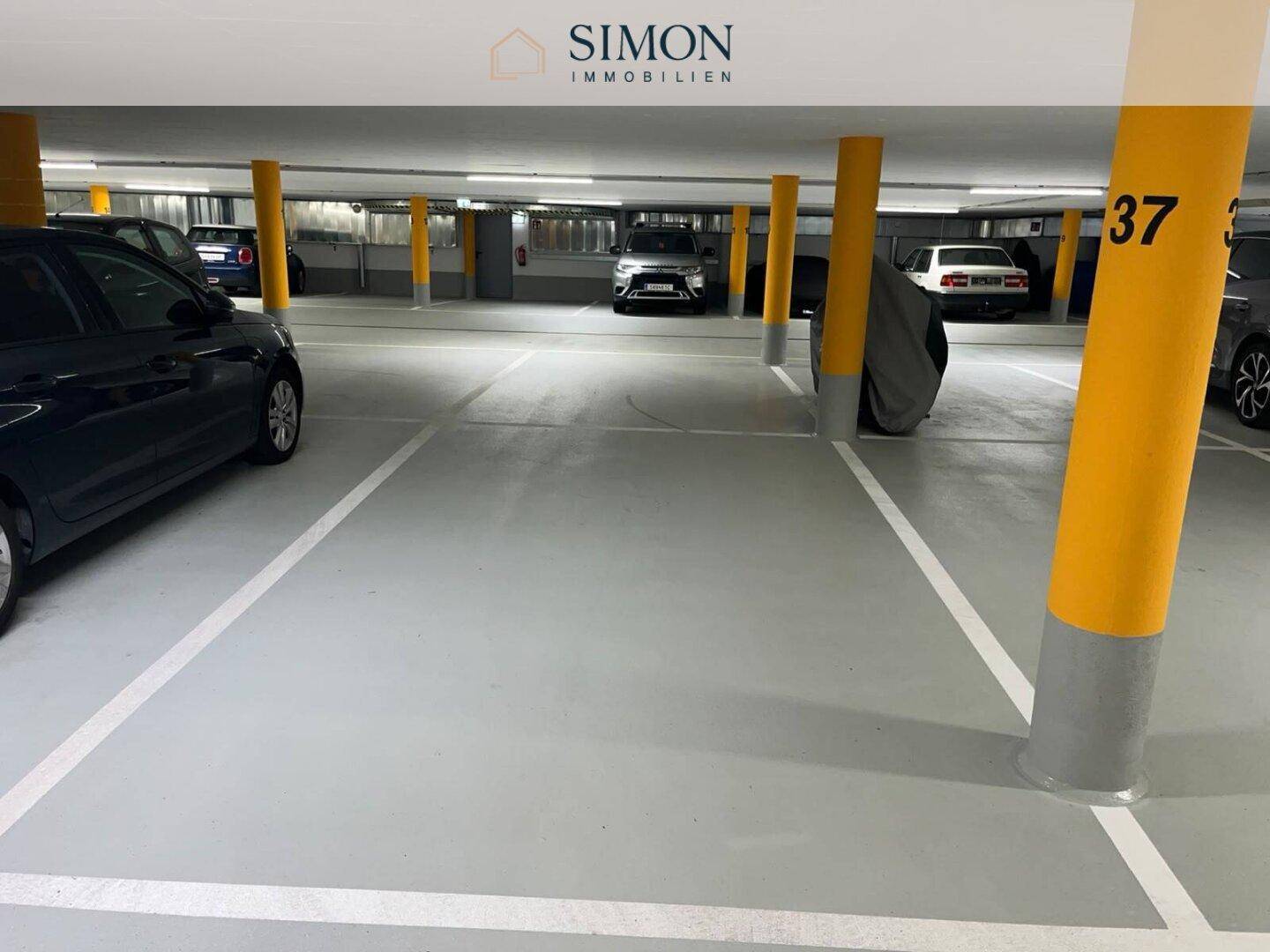 Tiefgarage mit markierten Stellplätzen und gelben Säulen, gut beleuchtet.