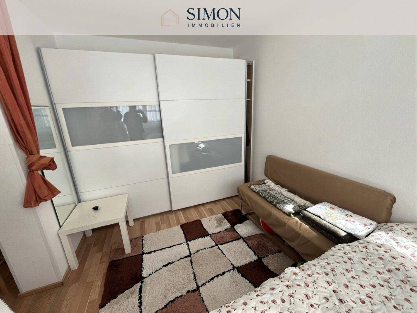 Schlafzimmer mit großem Schiebeschrank, Holzboden und gemütlichem Ambiente.