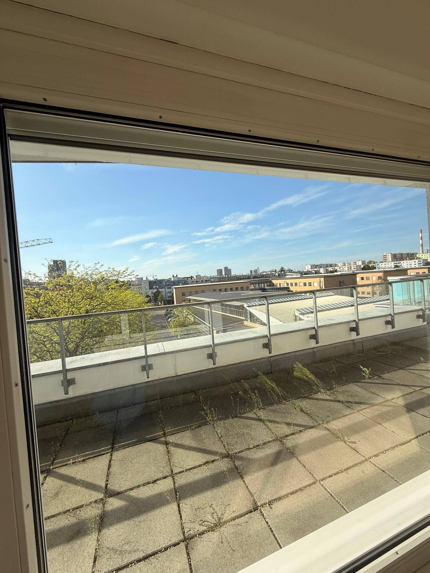 Geräumige Dachterrasse mit Stadtblick und viel Tageslicht, ideal für Entspannung im Freien.