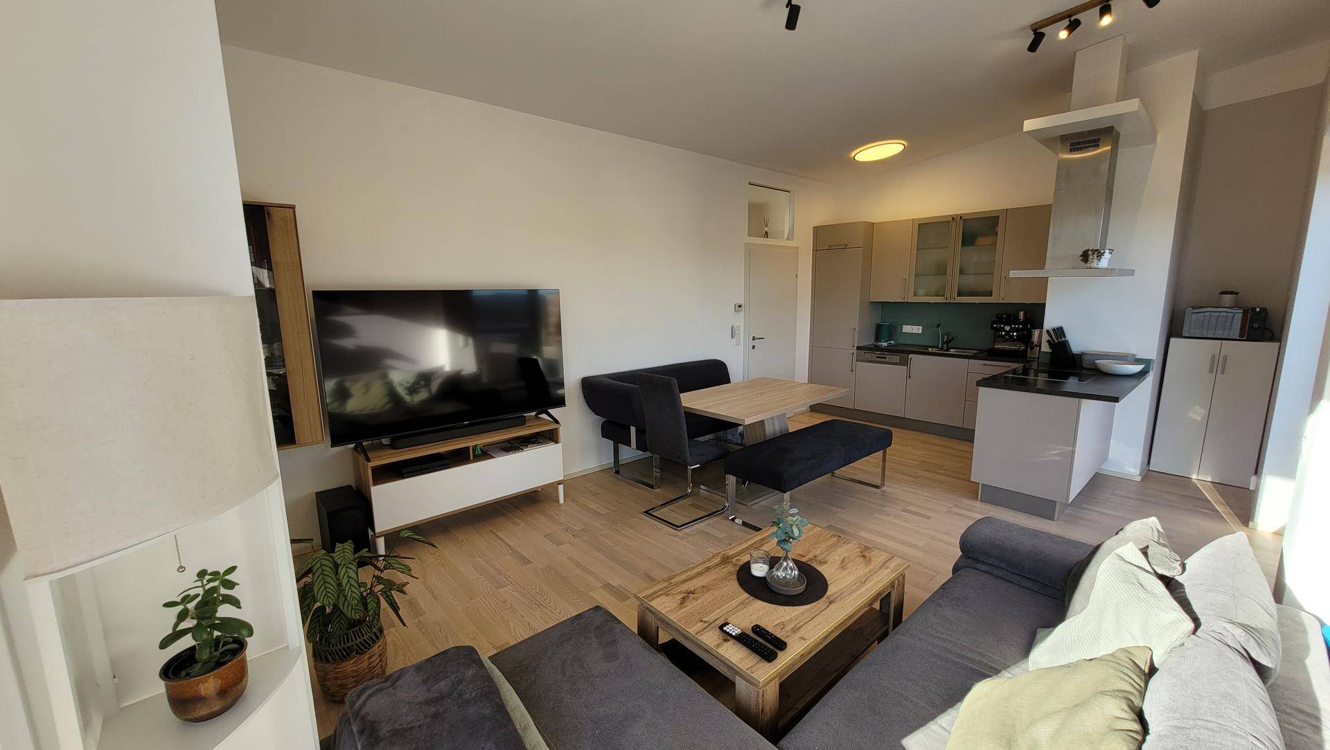 Moderner offener Wohn-Essbereich mit voll ausgestatteter Küche und gemütlicher Sitzecke.