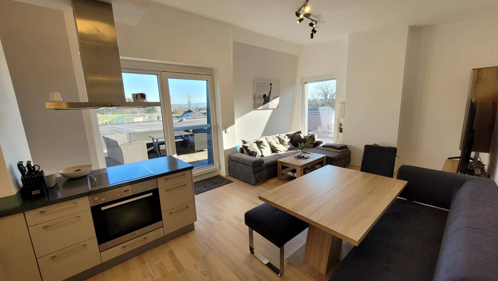 Offener Wohn-Essbereich mit integrierter Küche und direktem Zugang zur sonnigen Terrasse.