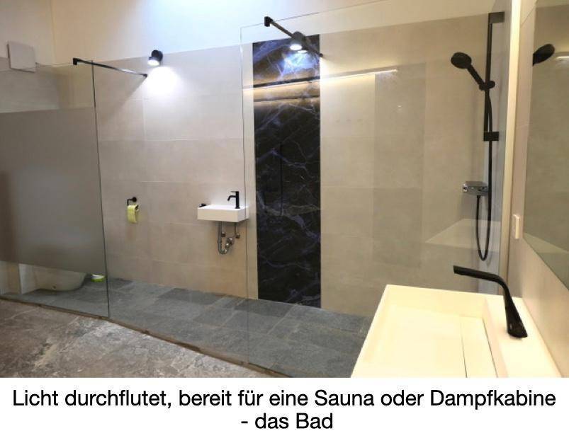 Lichtdurchflutetes Badezimmer mit begehbarer Dusche, modernen Fliesen und Vorbereitung für Sauna oder Dampfkabine.