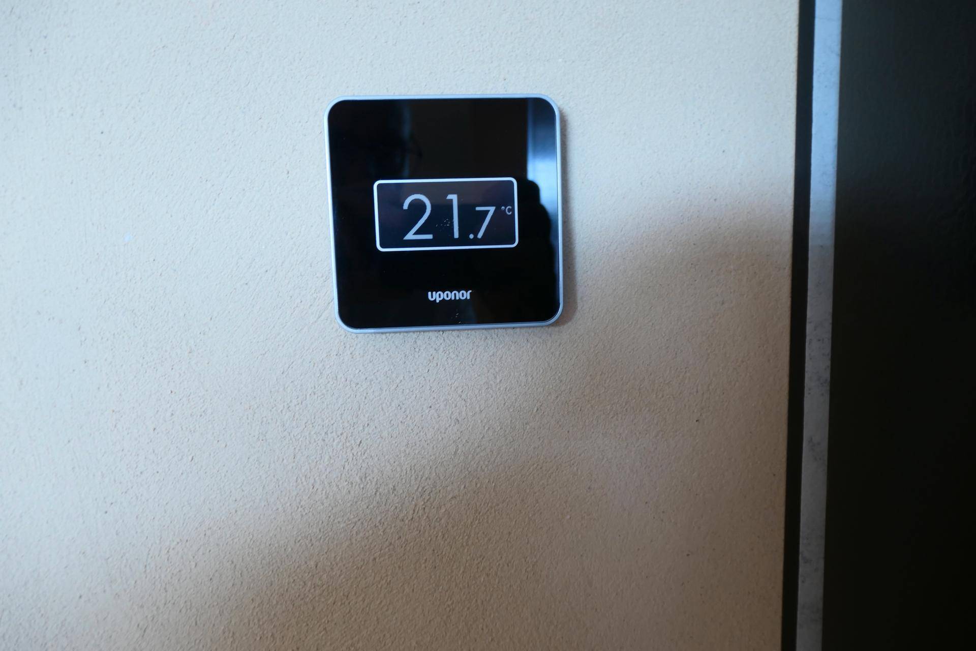 Digitaler Thermostat an der Wand, der die aktuelle Raumtemperatur von 21,7°C anzeigt.