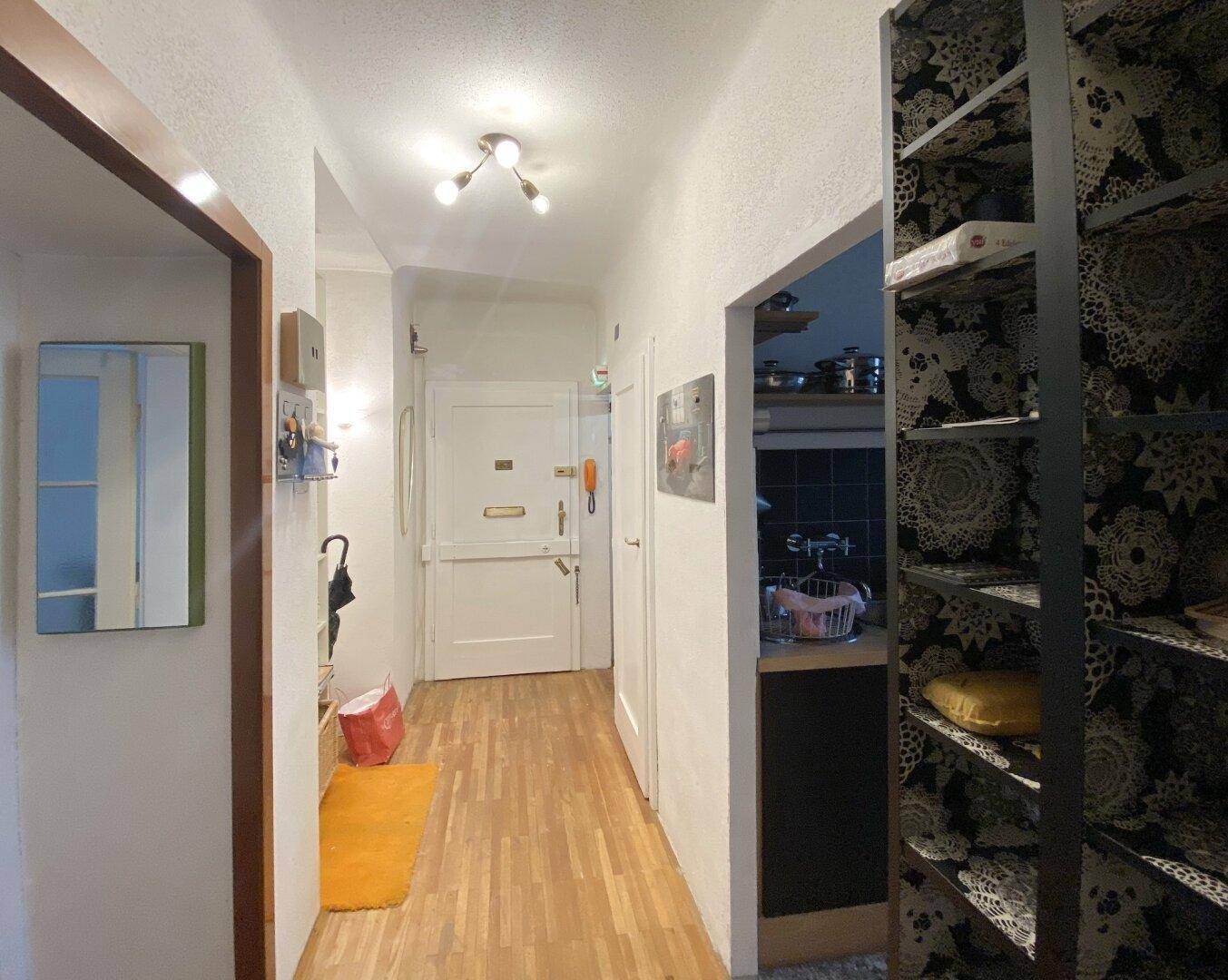 Heller Flur mit Holzboden, Garderobe und Zugang zu weiteren Räumen.