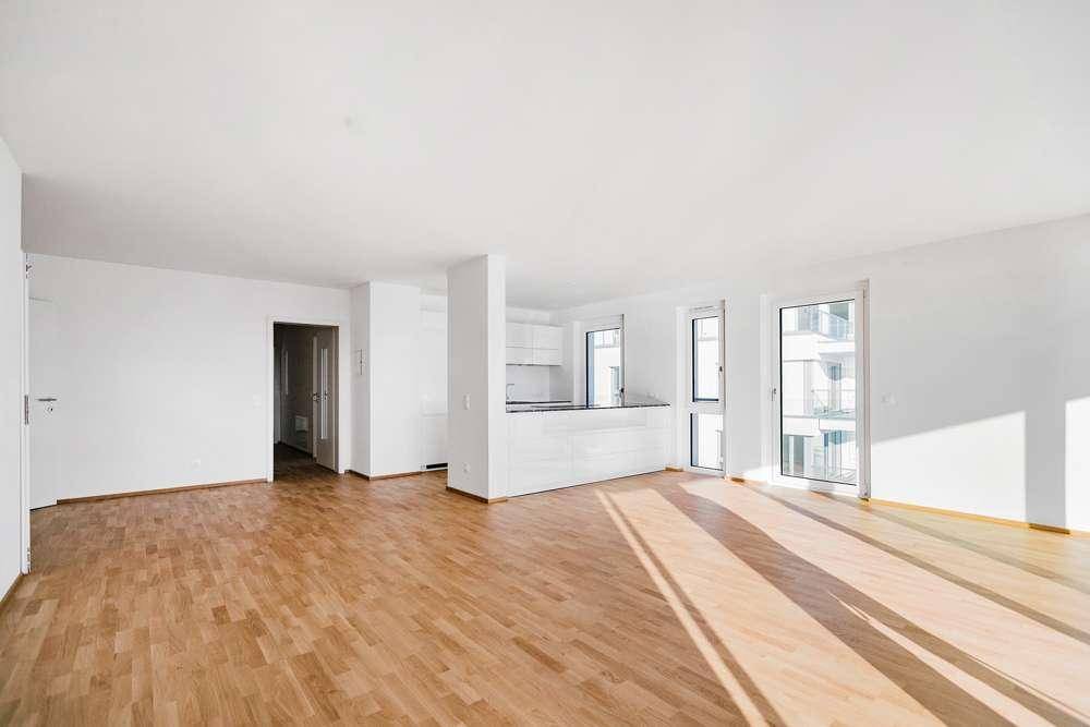 Lichtdurchfluteter Wohnbereich mit Holzboden und integrierter Küchenzeile, ideal für offenes Wohnen.