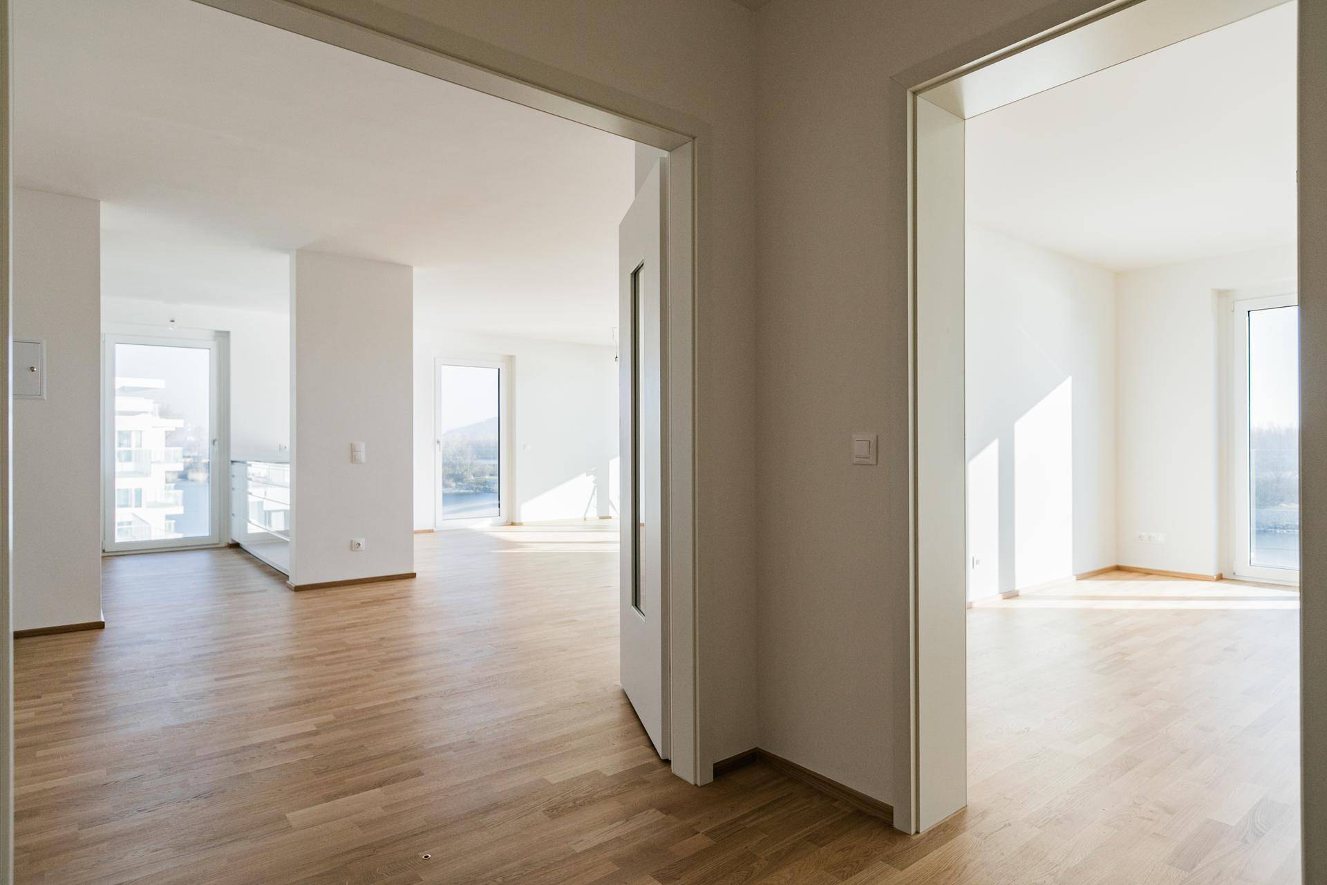 Offener Grundriss mit hellem Parkettboden, der verschiedene Wohnbereiche miteinander verbindet.