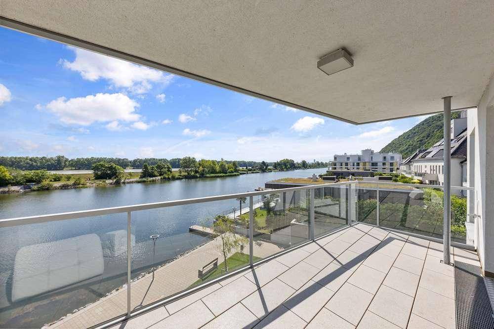 Große Terrasse mit Glasgeländer und Panoramablick auf den Fluss und die grüne Hügellandschaft.