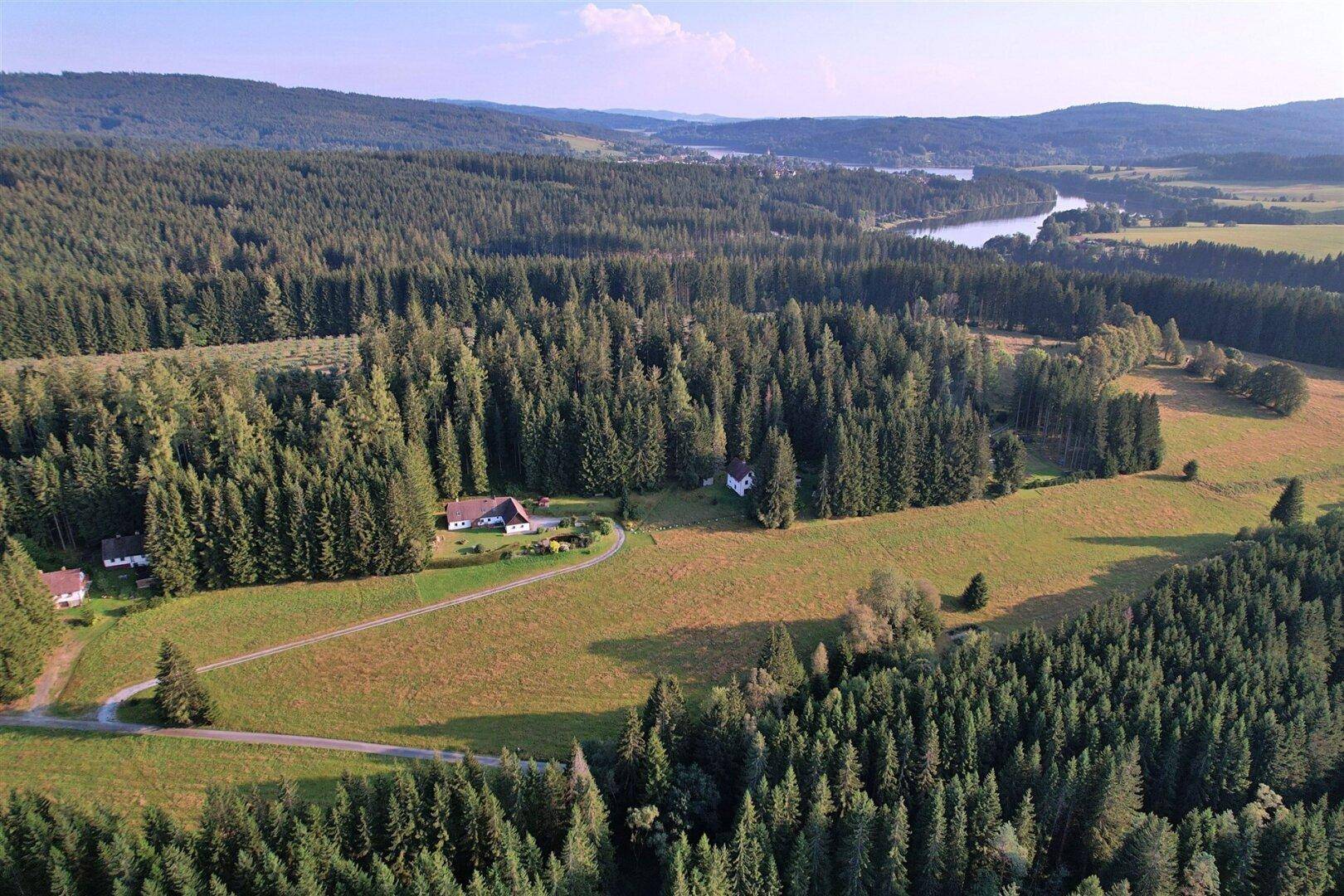Luftaufnahme des Anwesens mit weiten Wäldern, Feldern und einem Fluss in der Ferne.